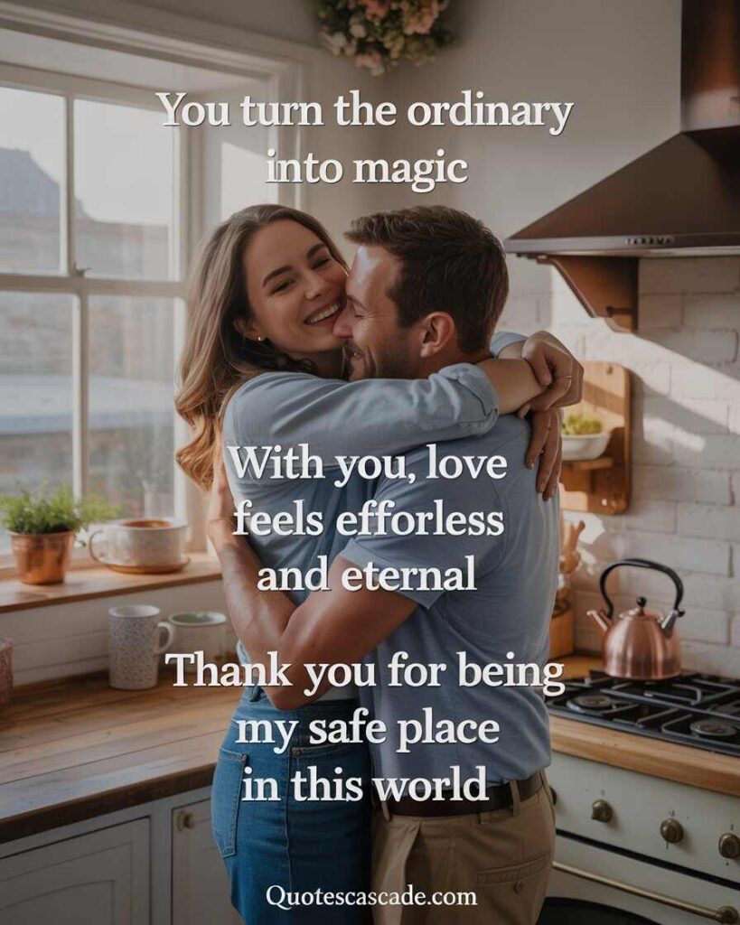 A cozy and heartwarming scene of a romantic couple embracing in a sunlit kitchen. The woman, with long light brown hair, wears a blue top and jeans, smiling warmly while hugging a man with short brown hair wearing a light blue shirt and beige pants. The kitchen has warm tones, white cabinets, a copper kettle, potted plants, and sunlight streaming through the window. There are mugs on the counter. Text overlay in elegant serif font reads: “You turn the ordinary into magic. With you, love feels effortless and eternal. Thank you for being my safe place in this world.” At the bottom is the website name: QUOTESCASCADE.COM.